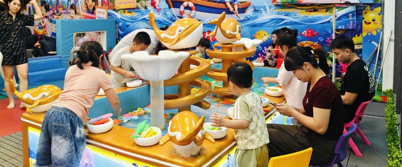 Bố mẹ ngồi cạnh các bé ở khu câu cá